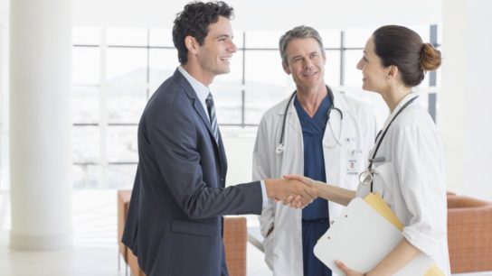 Doctors shake hands with businessman
