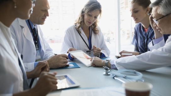Doctors using a tablet in a meeting