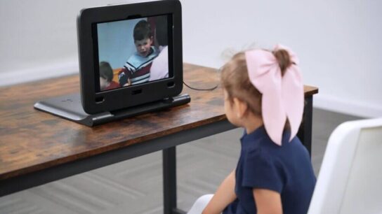Young-girl-sitting-at-a-desk-looking-at-digital-screen.