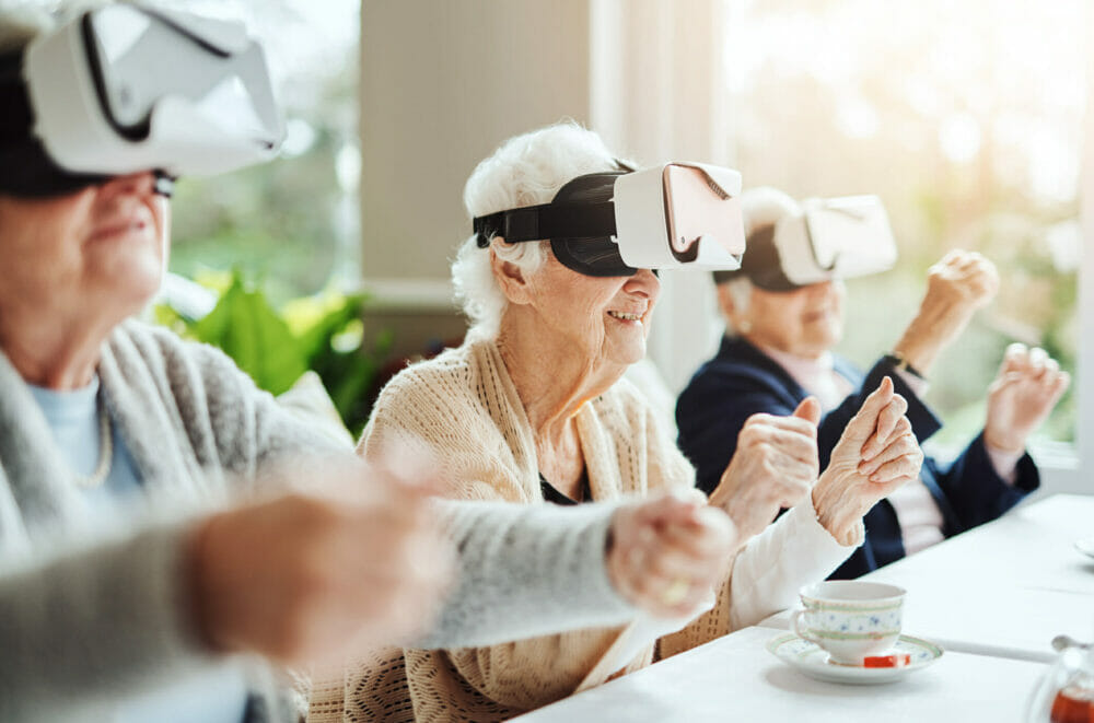 Close-up-of-senior-women-happy-using-virtual-reality-headset-at-a-retirement-home.