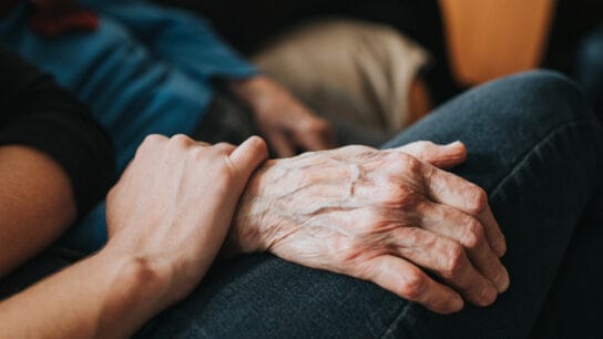 Conceptual. Younger person holding an older persons hand.