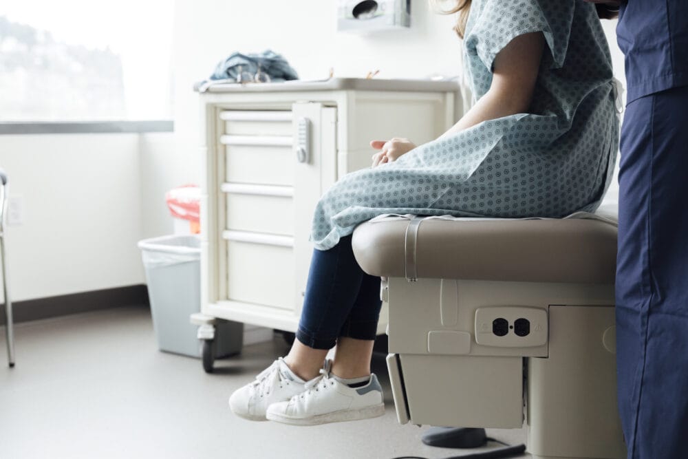 Female-nurse-examining-adolescent-patient-in-clinic.