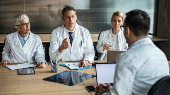 Team-of-doctors-communicating-with-their-colleague-during-a-meeting-in-the-office.