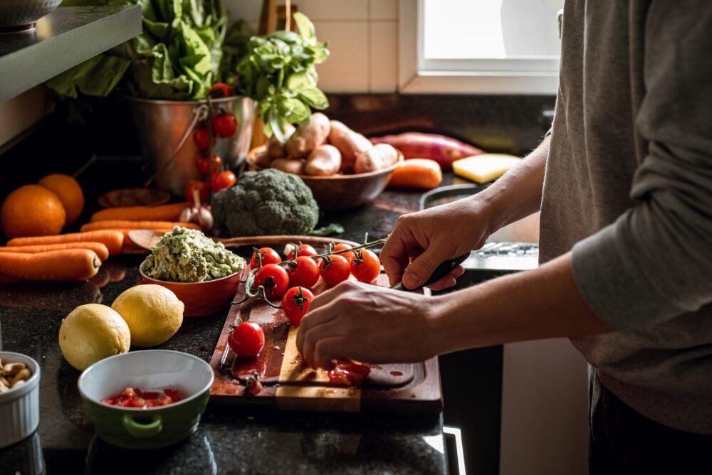 Shot-of-a-vegan-meal-preparation-with-lots-of-vegetables-and-fruits-on-a-domestic-kitchen