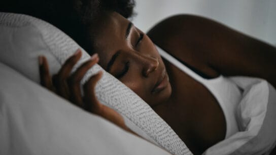 Young Black woman sleeping in bed