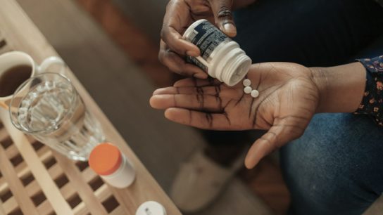 Woman Taking Out Pills From Bottle